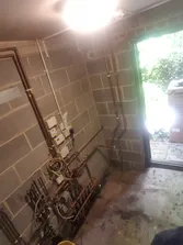 A room with a window and pipes in it.