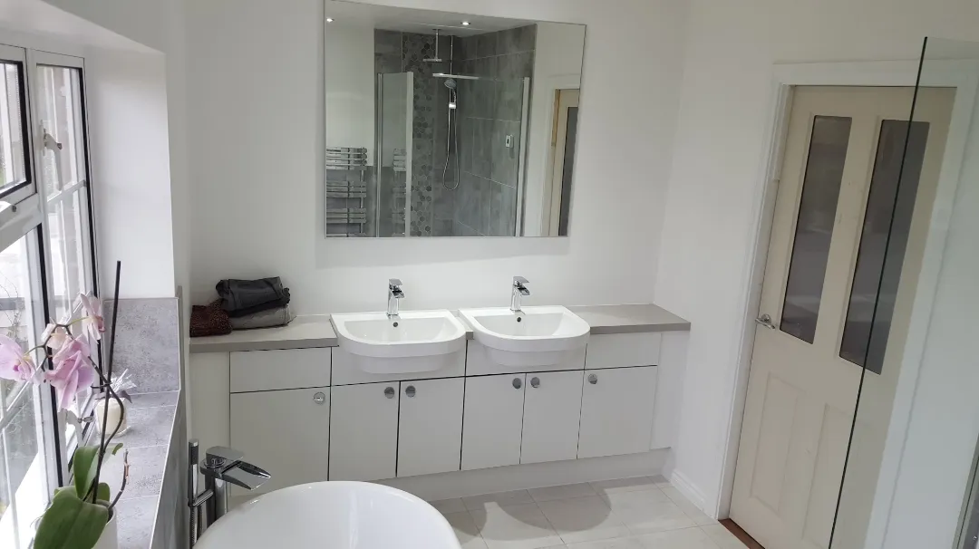 A bathroom with sinks and a door and a mirror