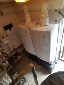 A white refrigerator sitting inside of a kitchen next to a window.