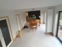 A room with a table, chairs, and a sliding glass door.