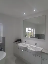 A bathroom with two sinks and a large mirror.