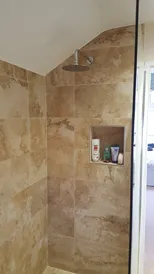 A walk in shower sitting next to a window.